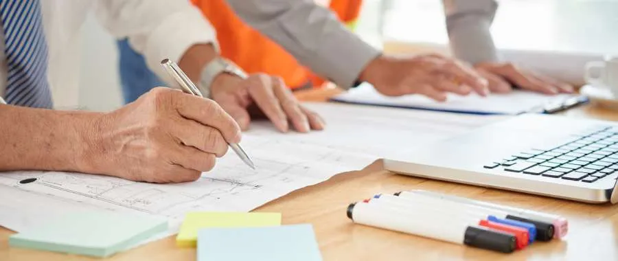 Engineers reviewing and annotating as-built construction documentation and plans