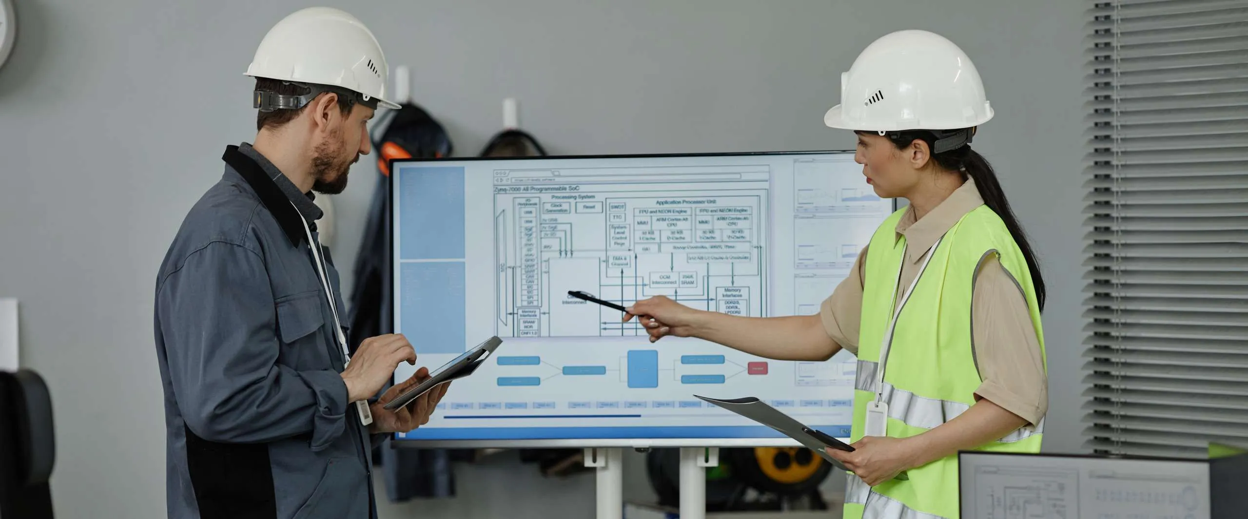 Engineers collaborating on MEP coordination services, reviewing technical drawings and designs on a screen