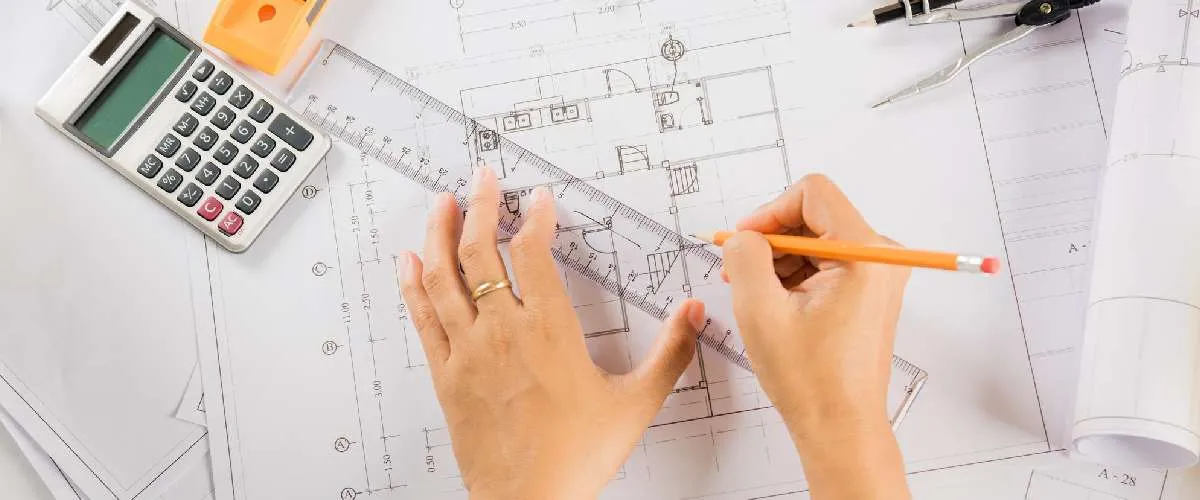 Engineer reviewing and measuring civil infrastructure plans with tools and drawings