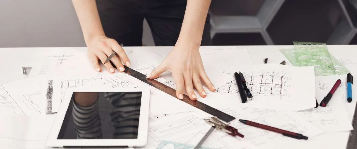 Engineer working on geometric dimensioning and tolerancing (GD&T) for architectural design with technical drawings