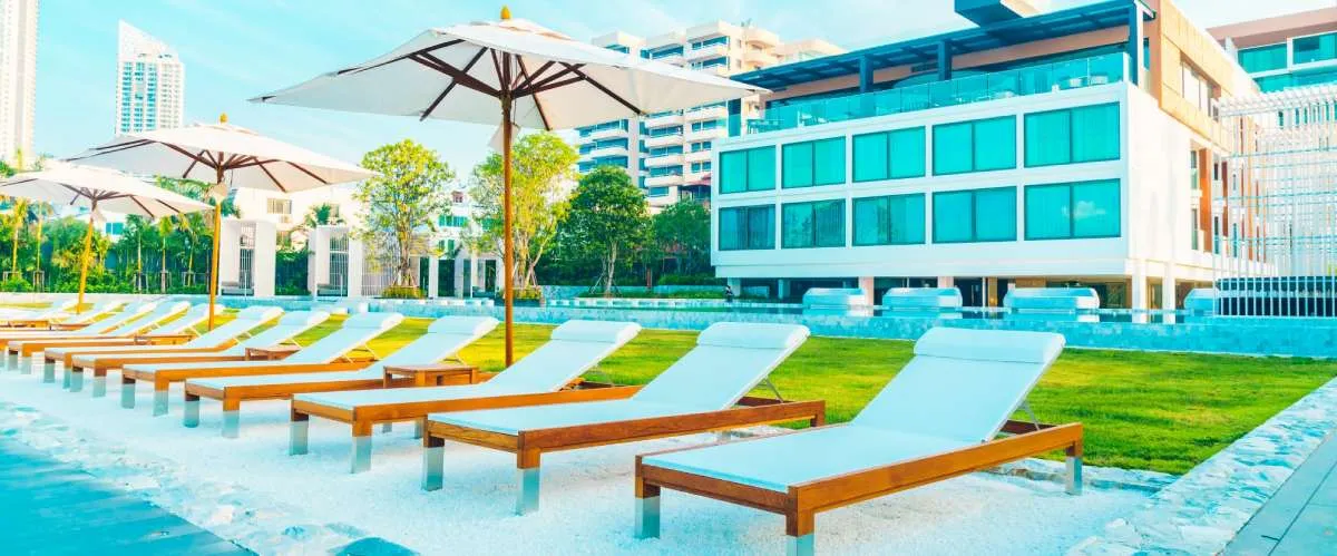 Hotel and leisure facility with modern poolside lounge chairs and building architecture